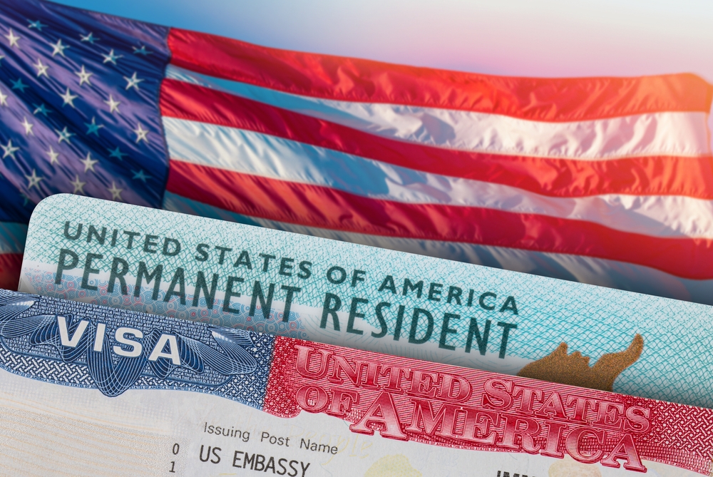 U.S. visa and permanent resident card with American flag background